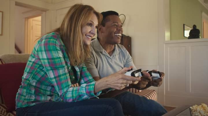 A happy couple game on console together. 